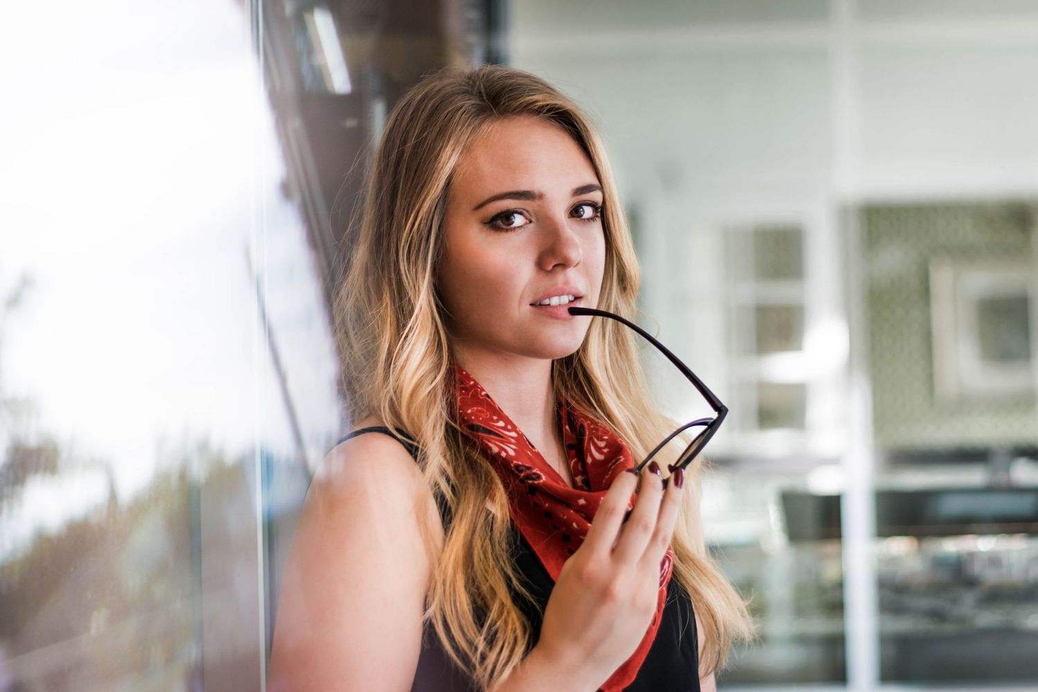 Woman near window with sunglasses in downtown Denver, Colorado