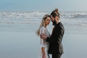 close up of a couple touching heads together on Brighton beach with the sea in the background