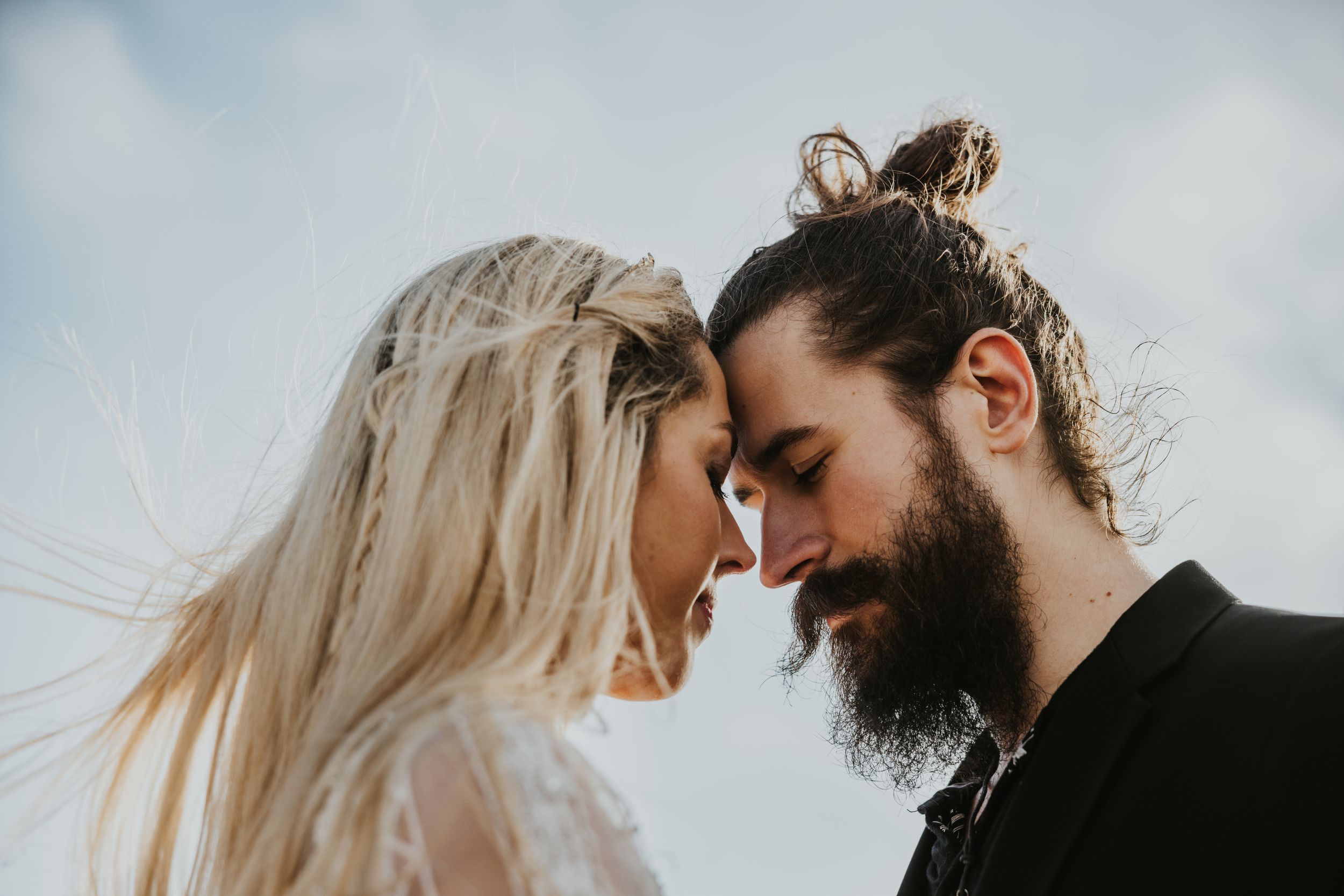 close up of a couple touching heads together on Brighton beach with the sea in the background
