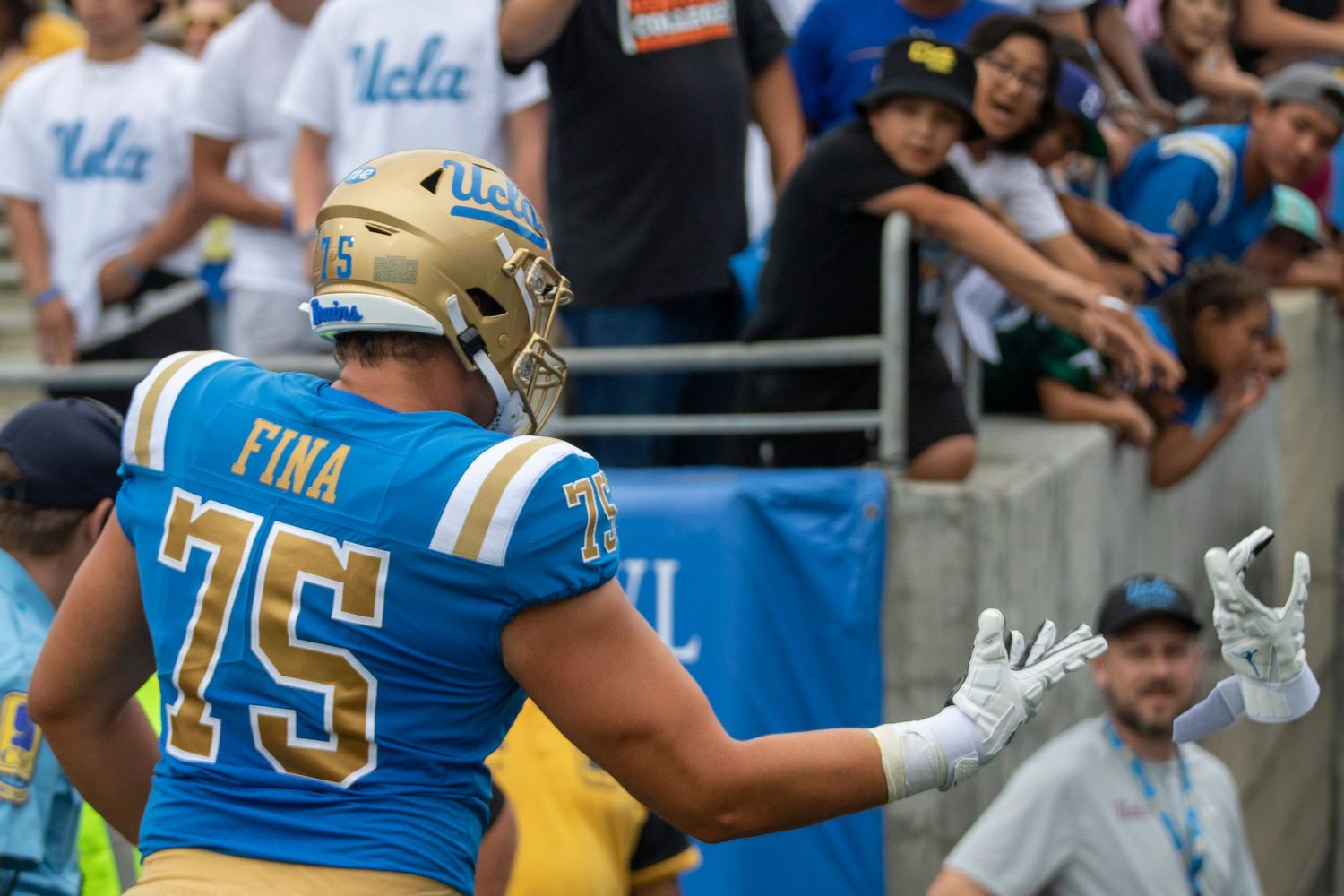 UCLA football player throwing a glove to a fan
