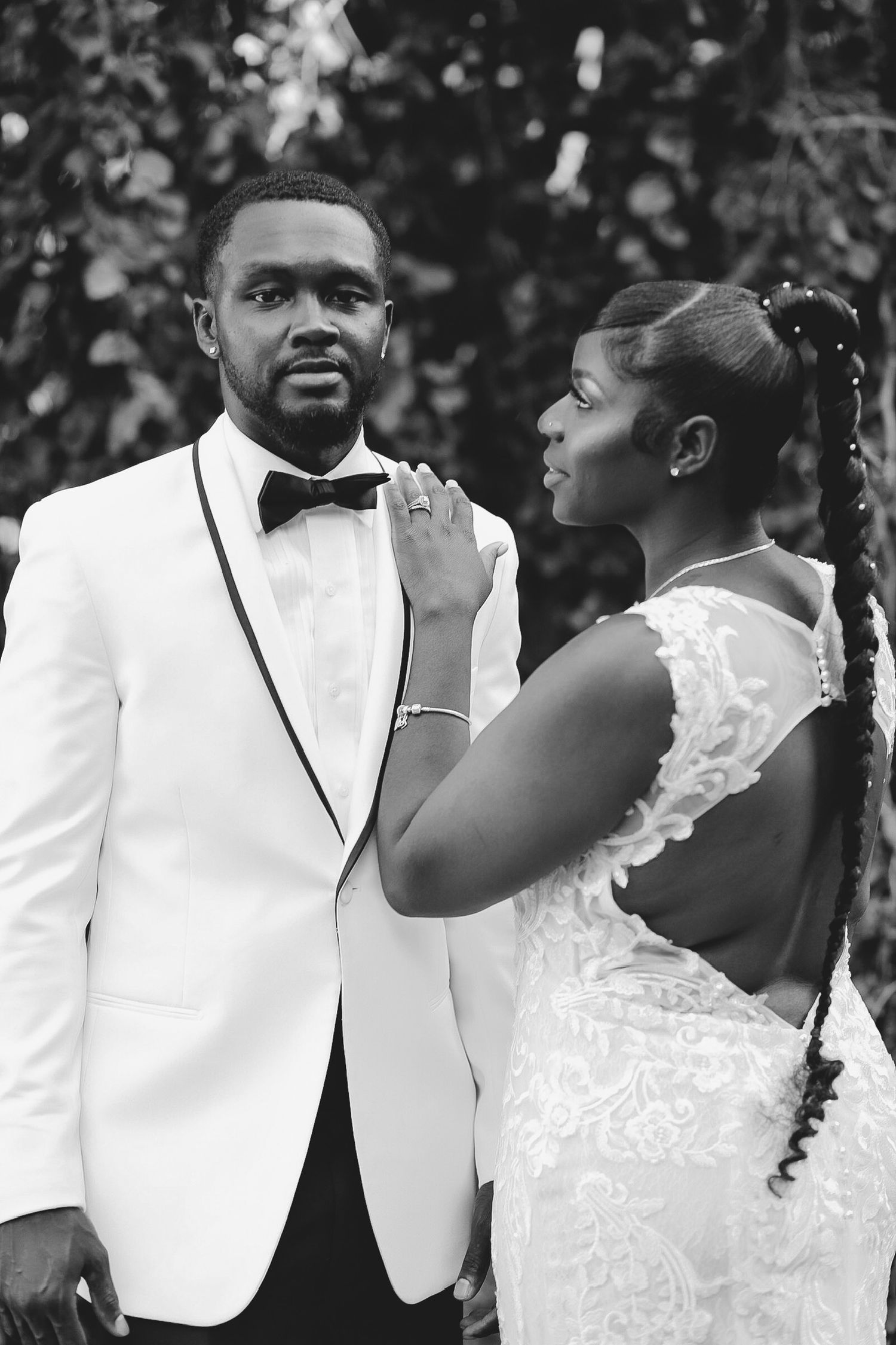Wedding couple in formal attire sharing an intimate moment outdoors.