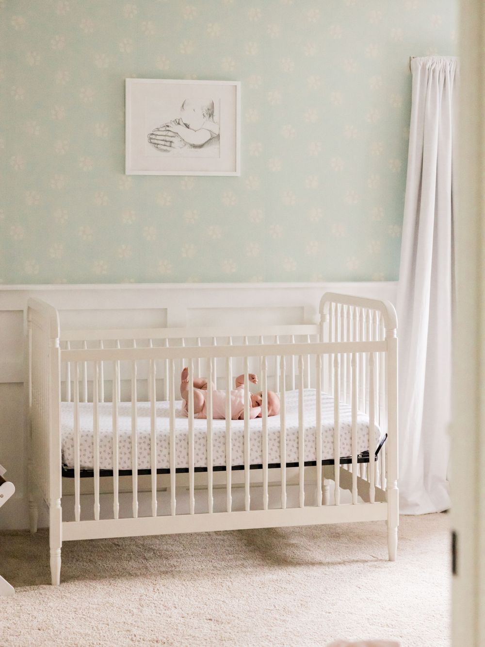 pale green nursery with infant in crib lifestyle photography