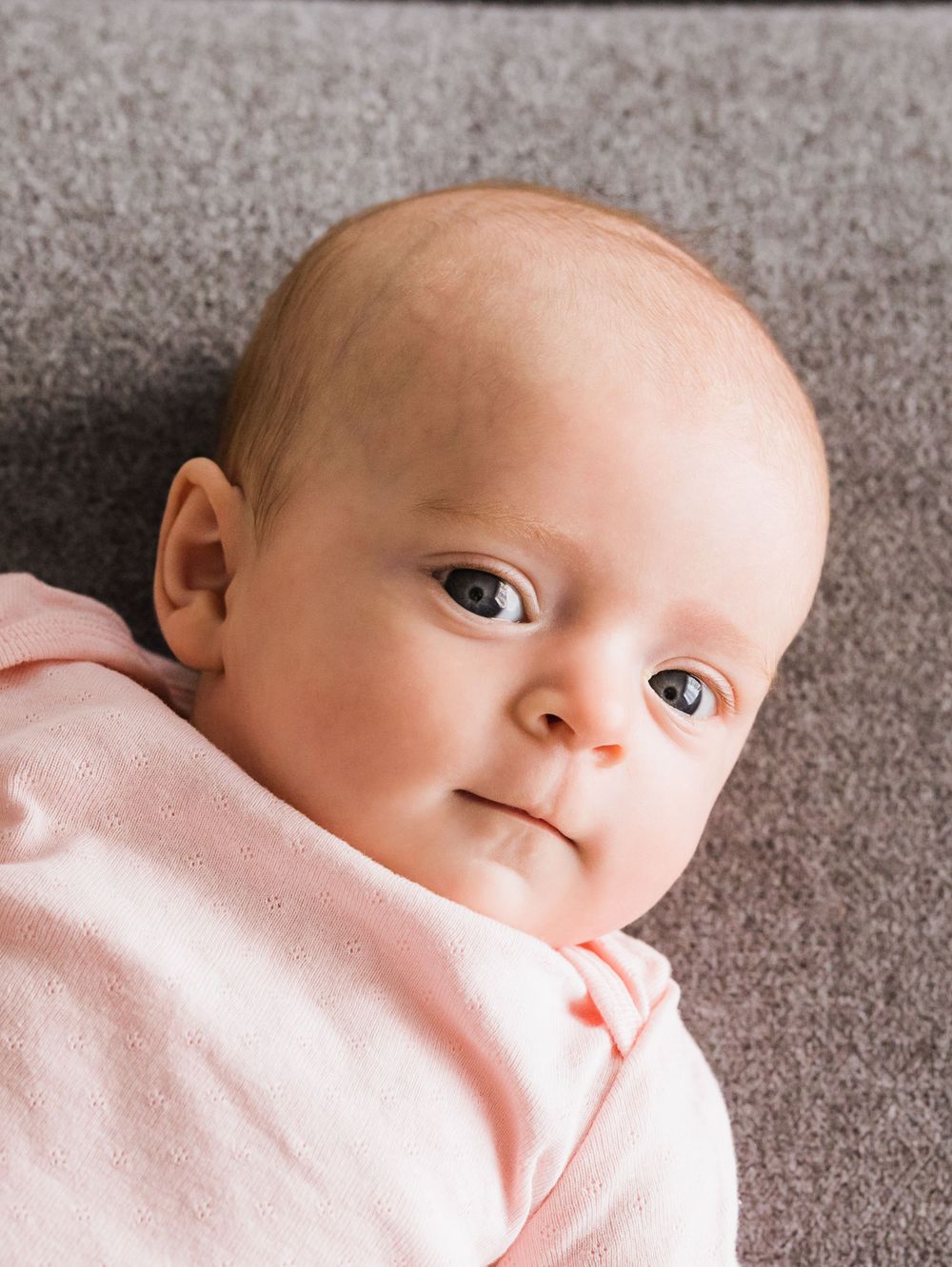 baby girl in pink looking at camera for infant lifestyle photography