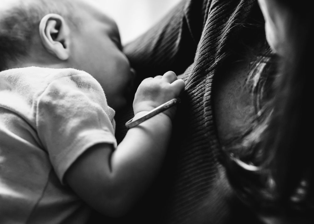 black and white photo of infant wearing heirloom bracelet lifestyle photo