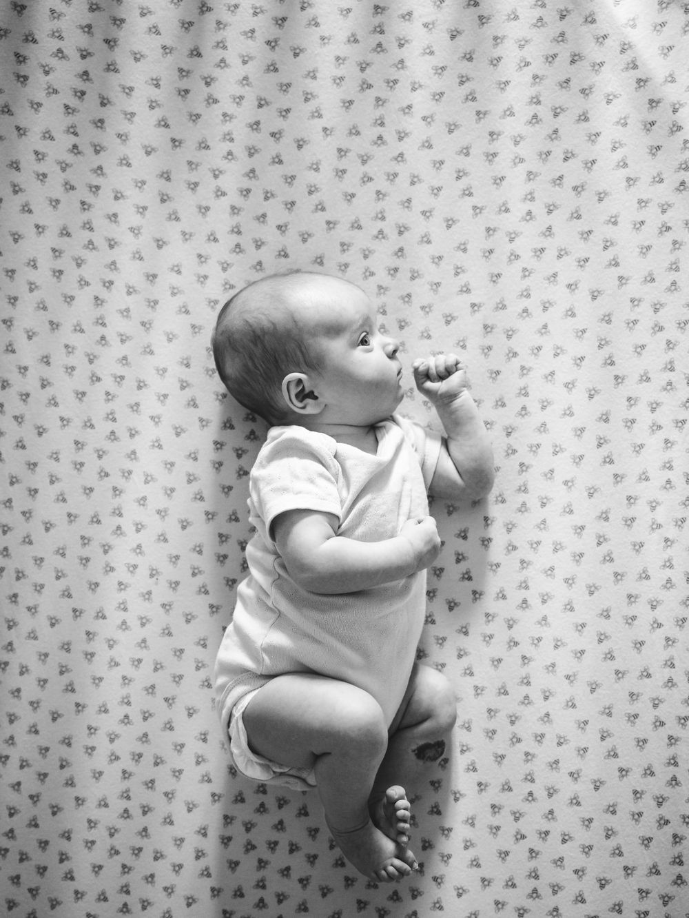 artistic lifestyle black and white image of shadows falling on baby profile in crib