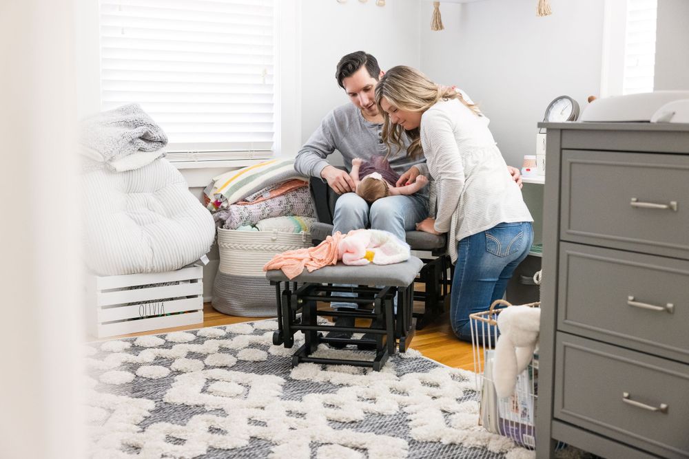 young couple looking at baby in nursery lifestyle photography for young families