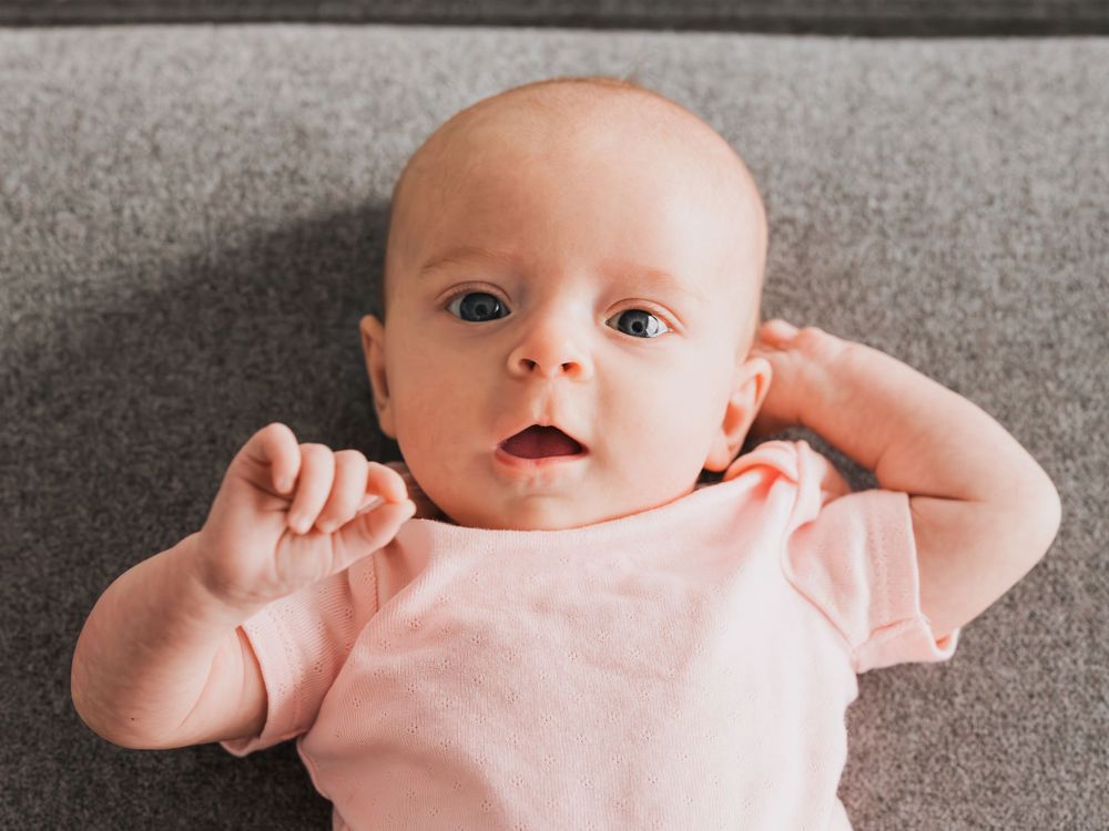 infant girl in pink onesie lifestyle photo