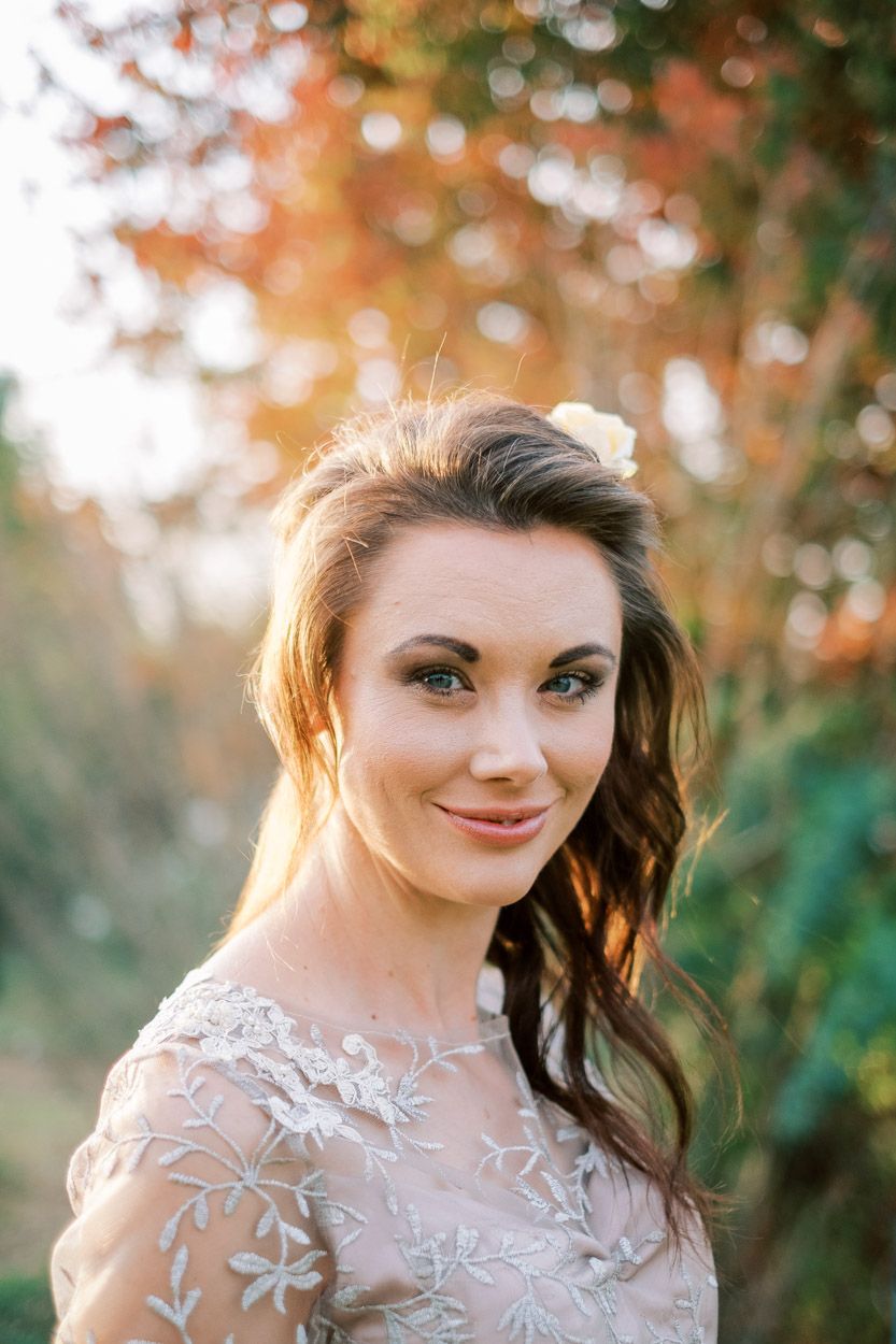 A bride stands in the garden at Rivieplaas Wedding Venue at sunset.