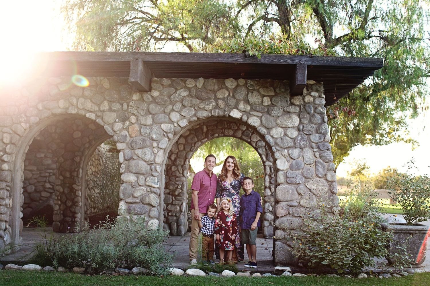 Family poses in front of rock arch at Santa Fe Dam in Irwindale.