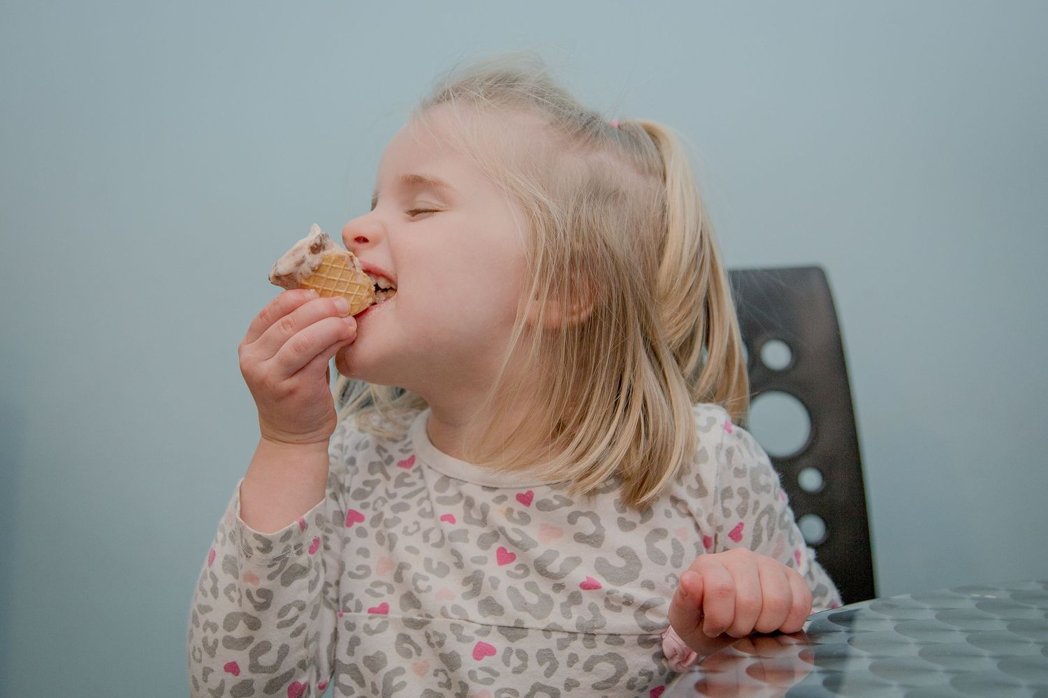 Girl Eating Ice Cream Cone at Ice Cream Shop