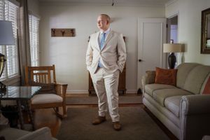man standing in a living-room wearing a tux
