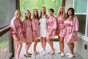 bride and bridesmaids posed together while getting ready before wedding