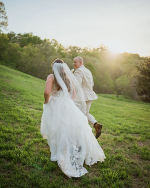 couple running in a field looking back at eachother