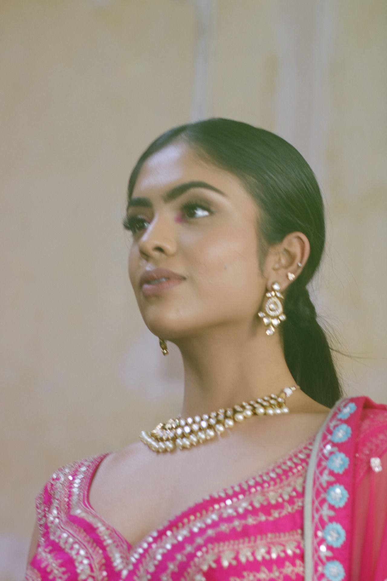 Traditional South Asian bridal jewelry with pearl necklace and ornate gold earrings.