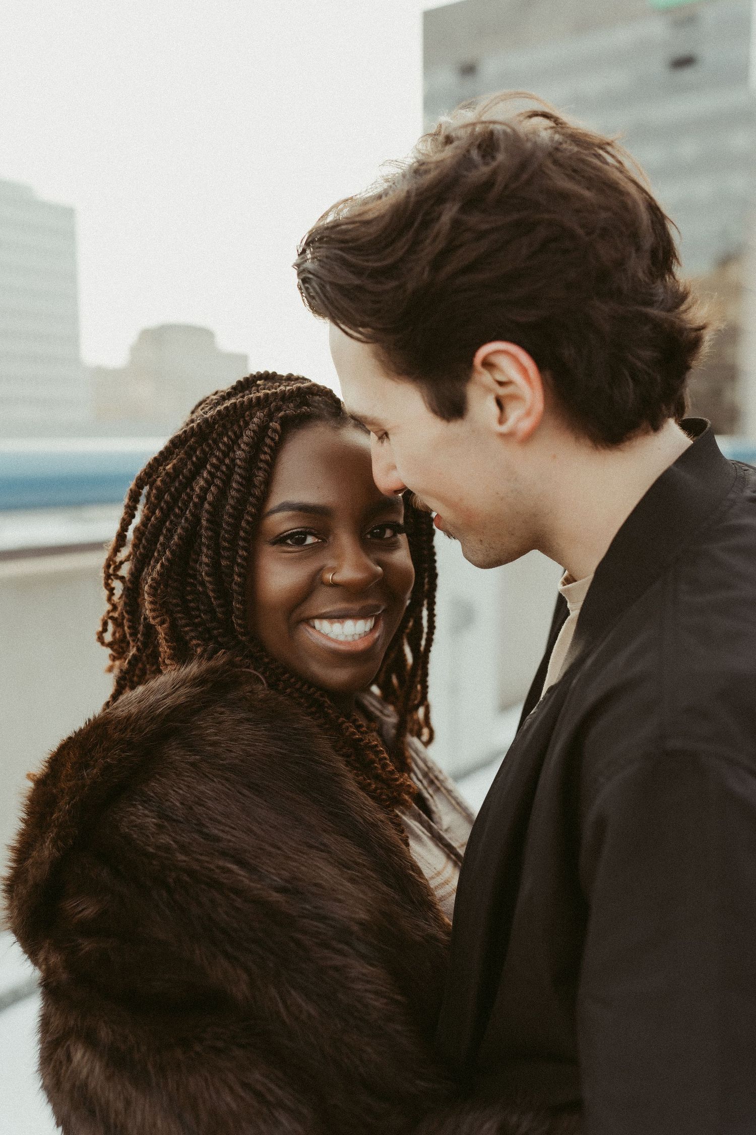 an interracial couple's rooftop engagement session during golden hour.