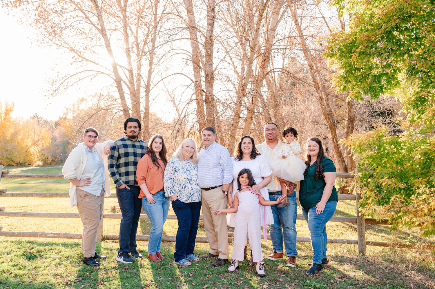 Group photo of extended family members standing together in an outdoor autumn setting.