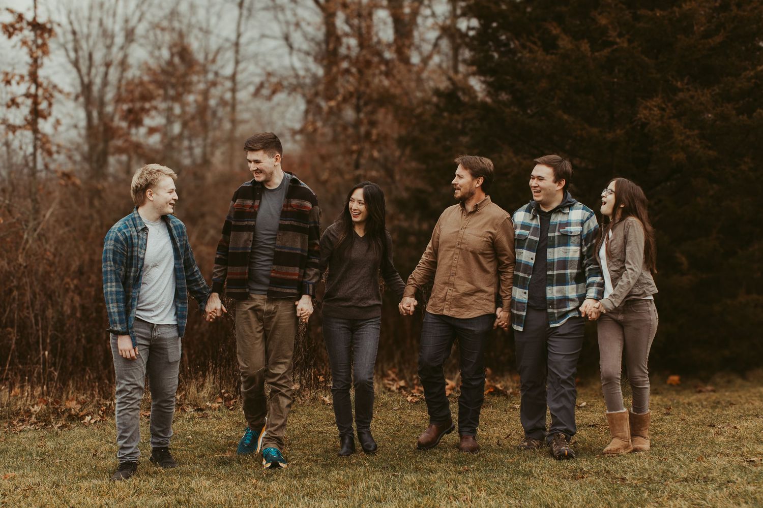 Group of people gathered outdoors in casual attire during fall season photoshoot.