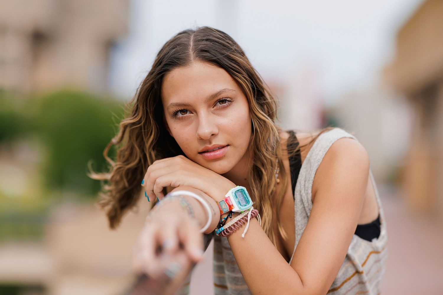 Casual street style portrait featuring digital watch and natural wavy hair.