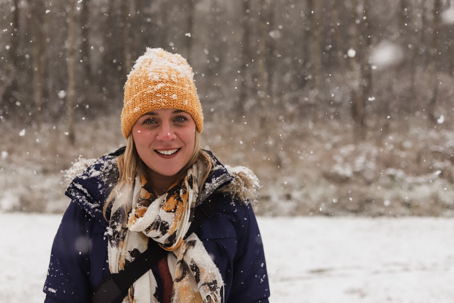 Image of photographer Holly Hancocks in the snow wearing a woolly hat and scarf