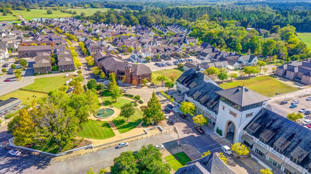 Aerial perspective of a small town with church spires and residential neighborhoods surrounded by greenery.