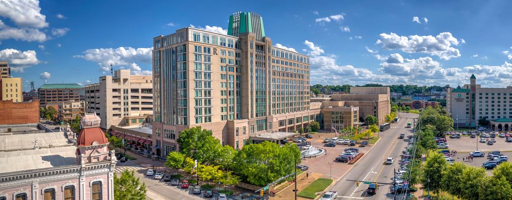 Panoramic view of downtown Durham showing modern buildings, historic architecture and tree-lined streets.