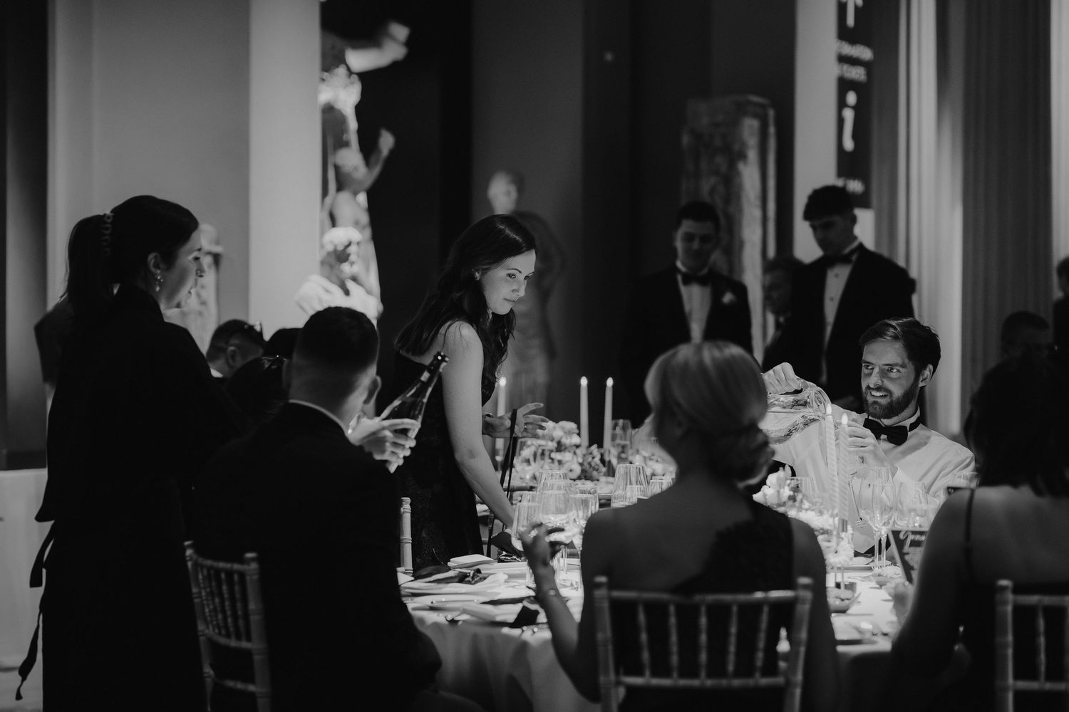 wedding guests sat around tables in the grand sculpture gallery at the Ashmolean Museum in Oxford