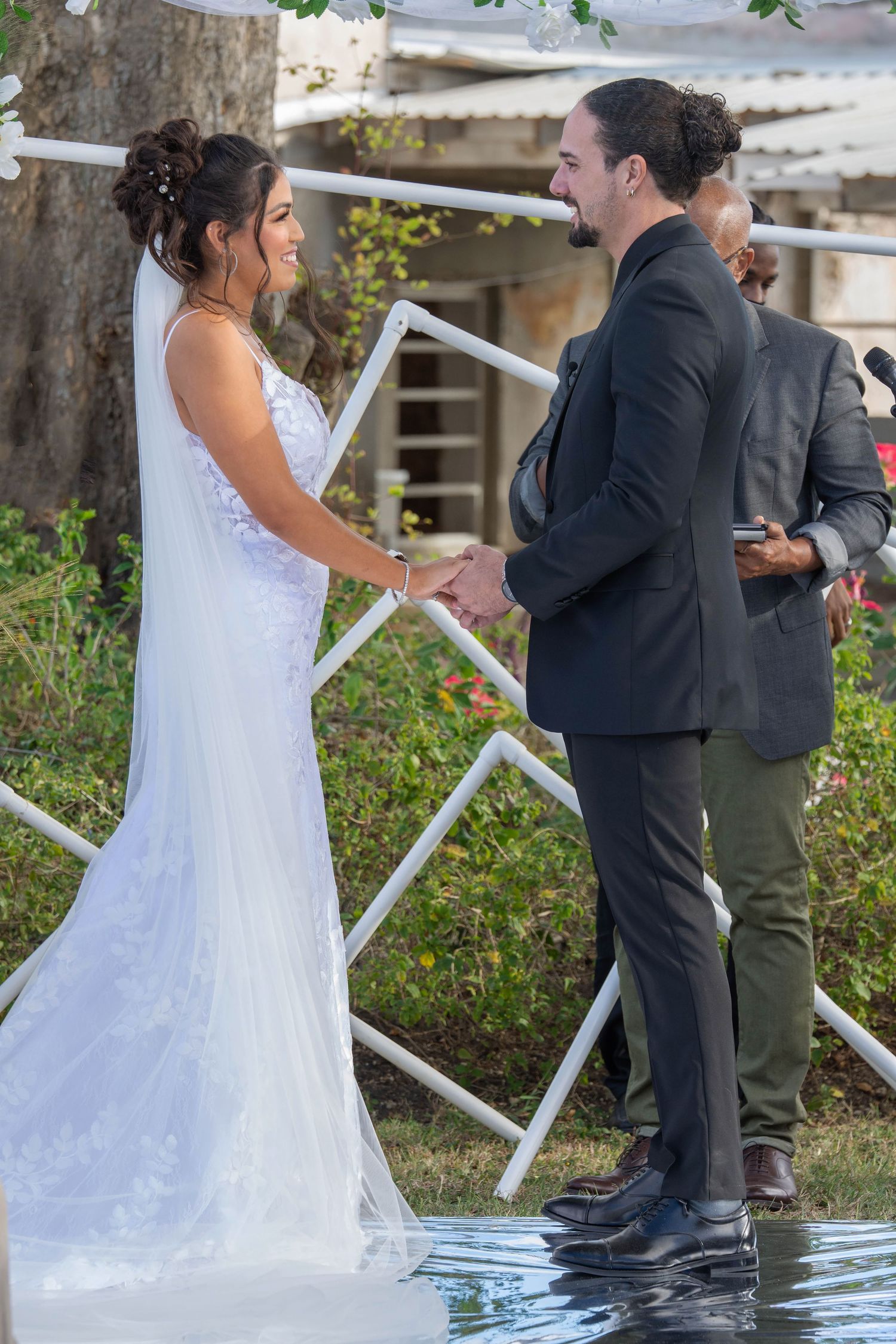 Sequence of photos showing a bride and groom sharing a lighthearted moment near a white railing during their wedding ceremony.