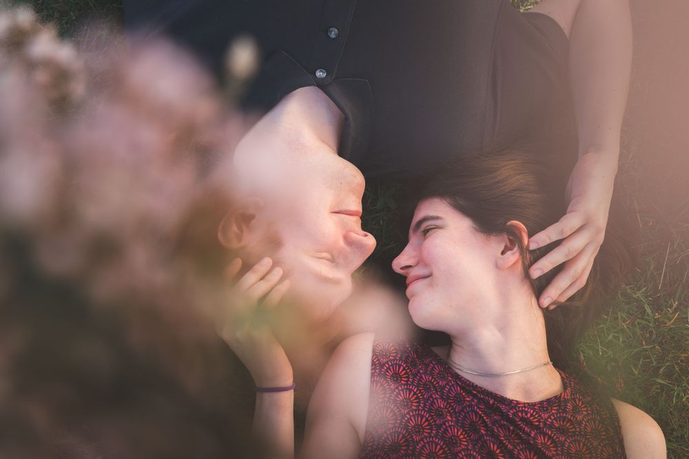 An intimate close-up portrait of a couple with soft focus and warm lighting.