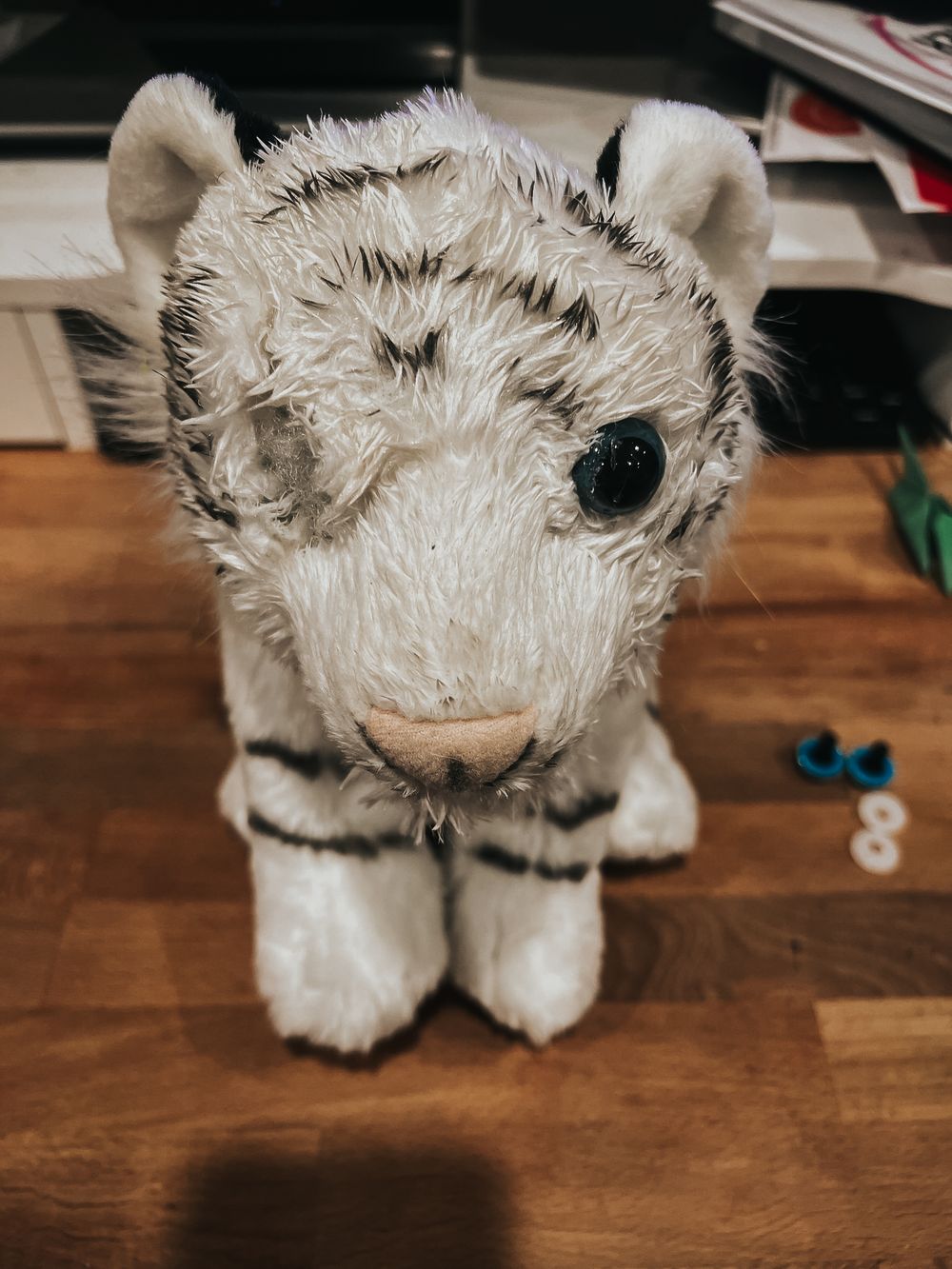 White stuffed tiger from Wild Republic with a missing eye and damaged muzzle.