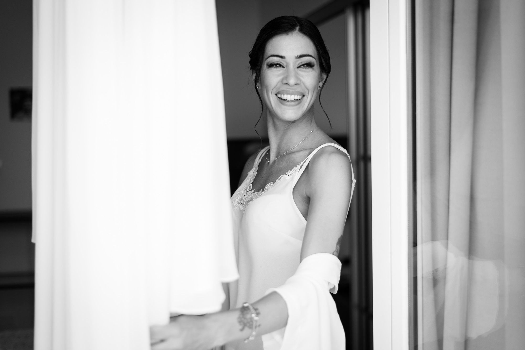 sposa alla finestra con l'abito appeso