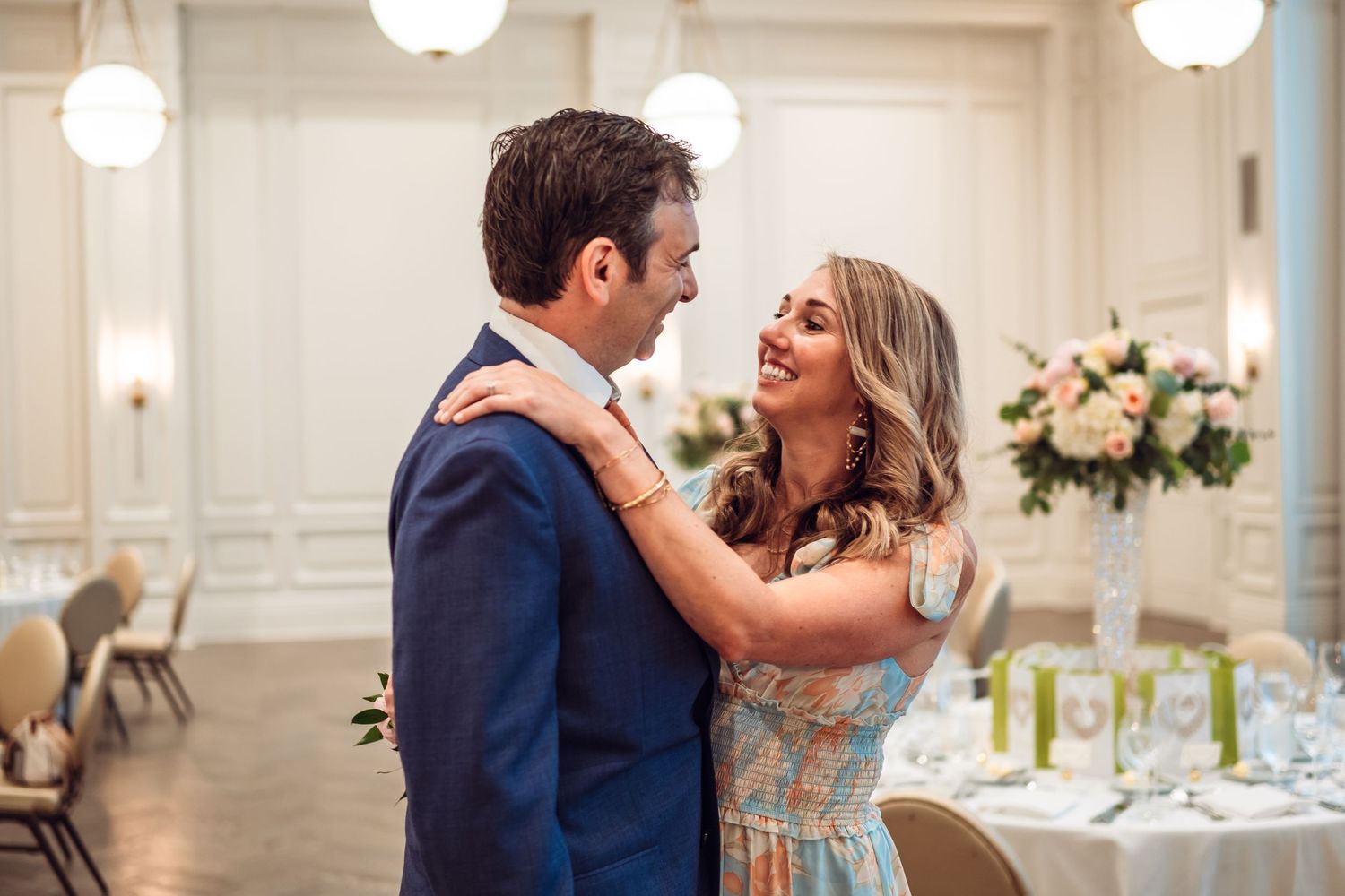 Elegant wedding reception celebration in a bright white ballroom.