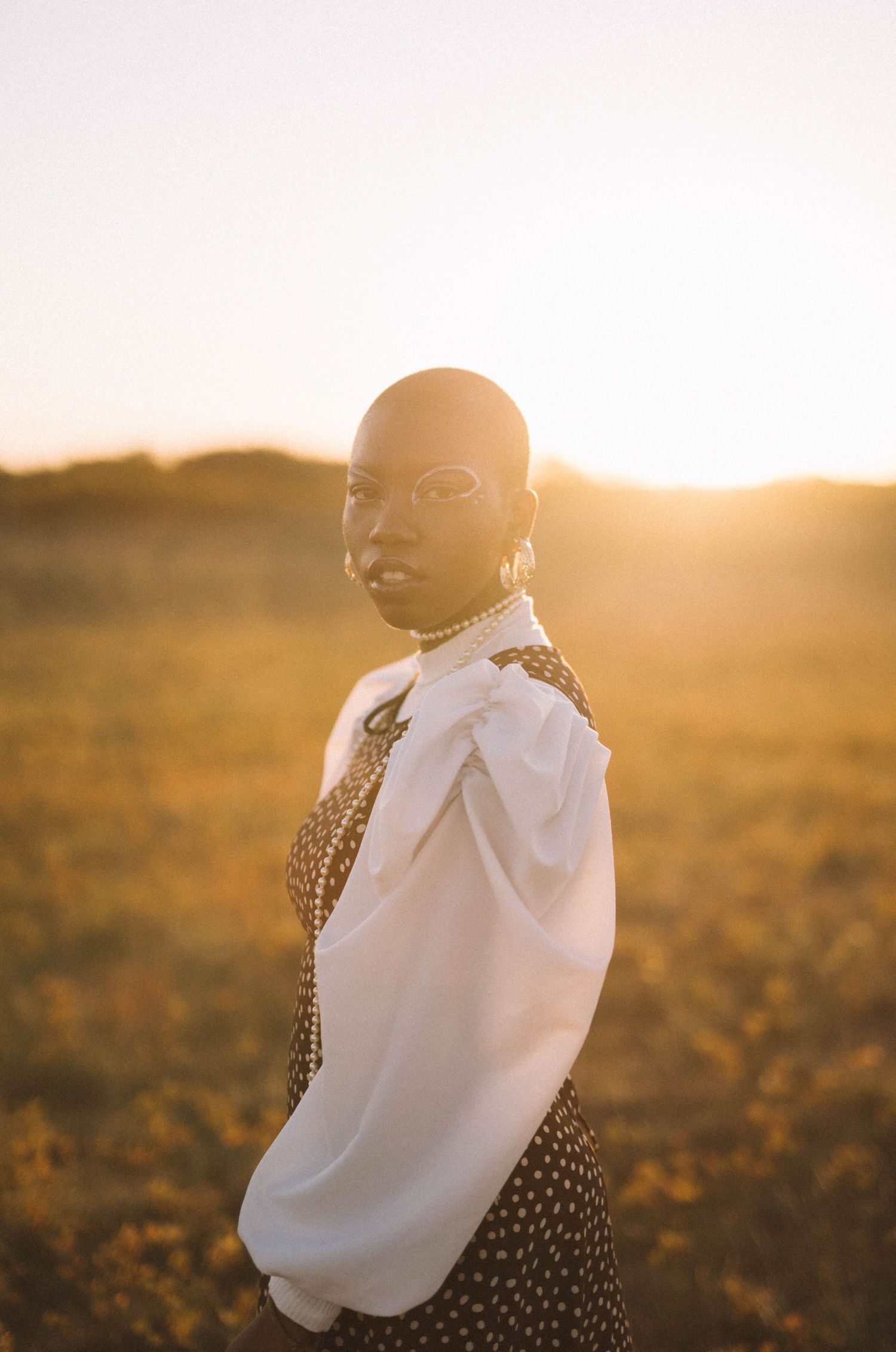 Portrait of someone in white blouse and leopard print at sunset in golden light.