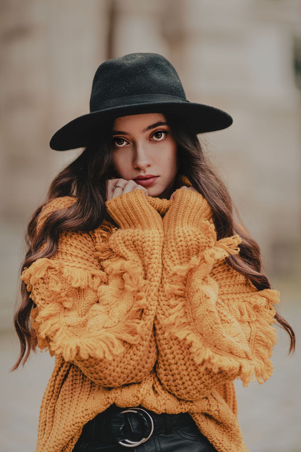 Cozy autumn fashion with oversized turtleneck sweater and black hat in warm tones.