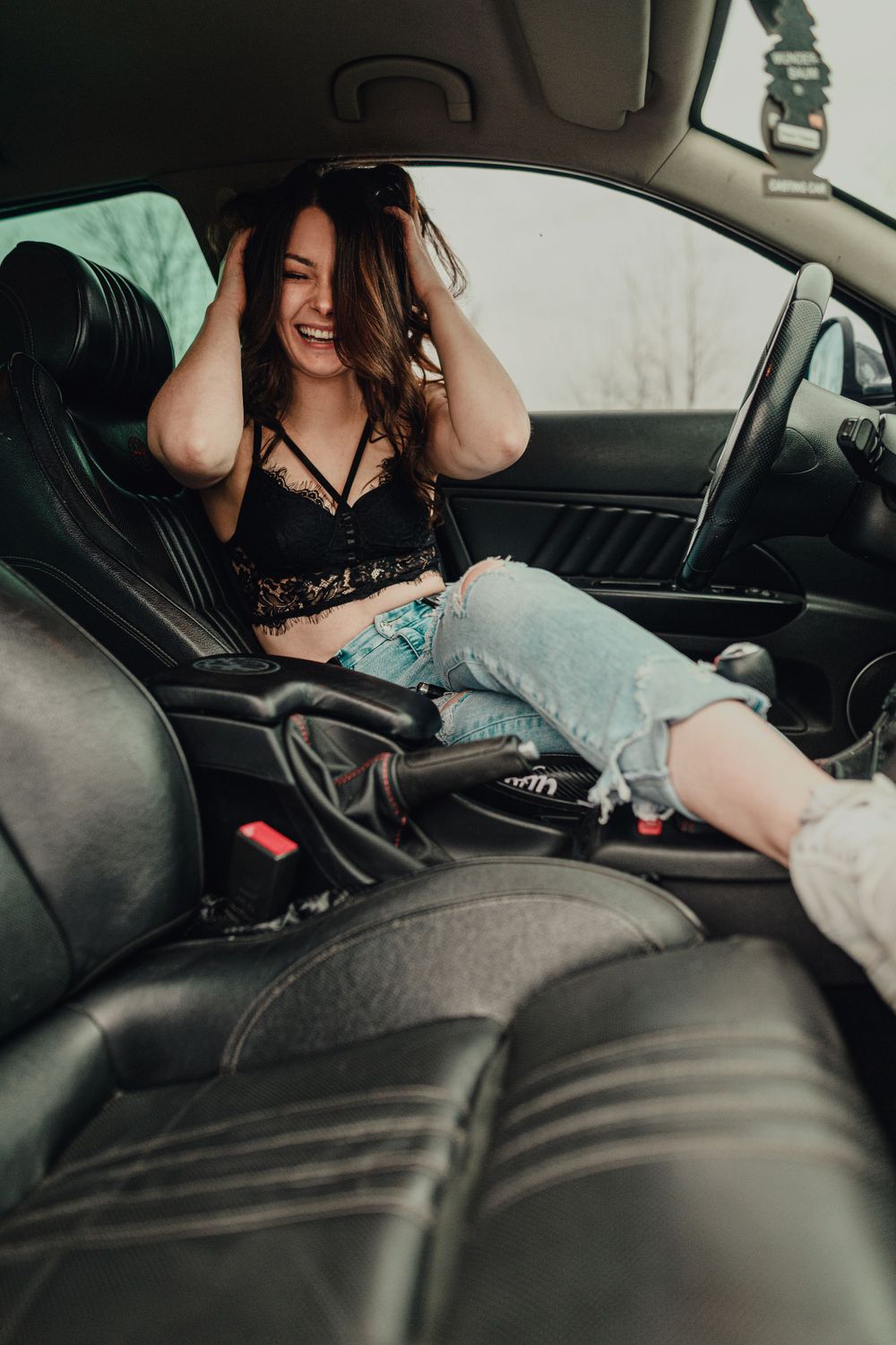 Intimate boudoir photography inside vintage car with leather interior.