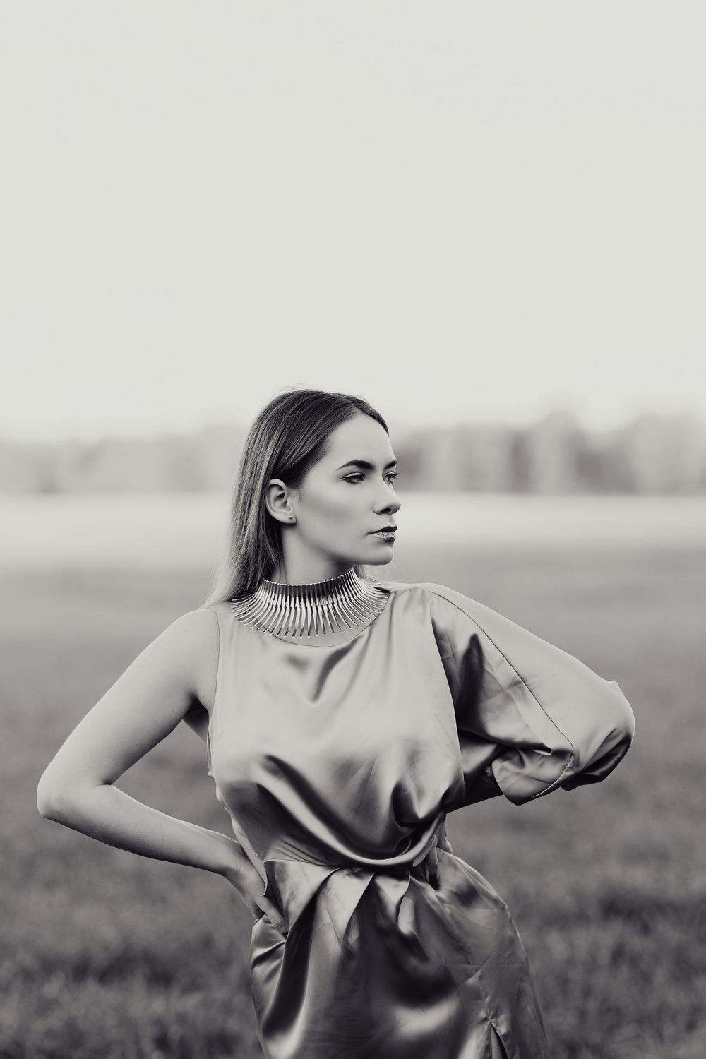 Dramatic black and white fashion portrait with structured dress and minimalist styling.