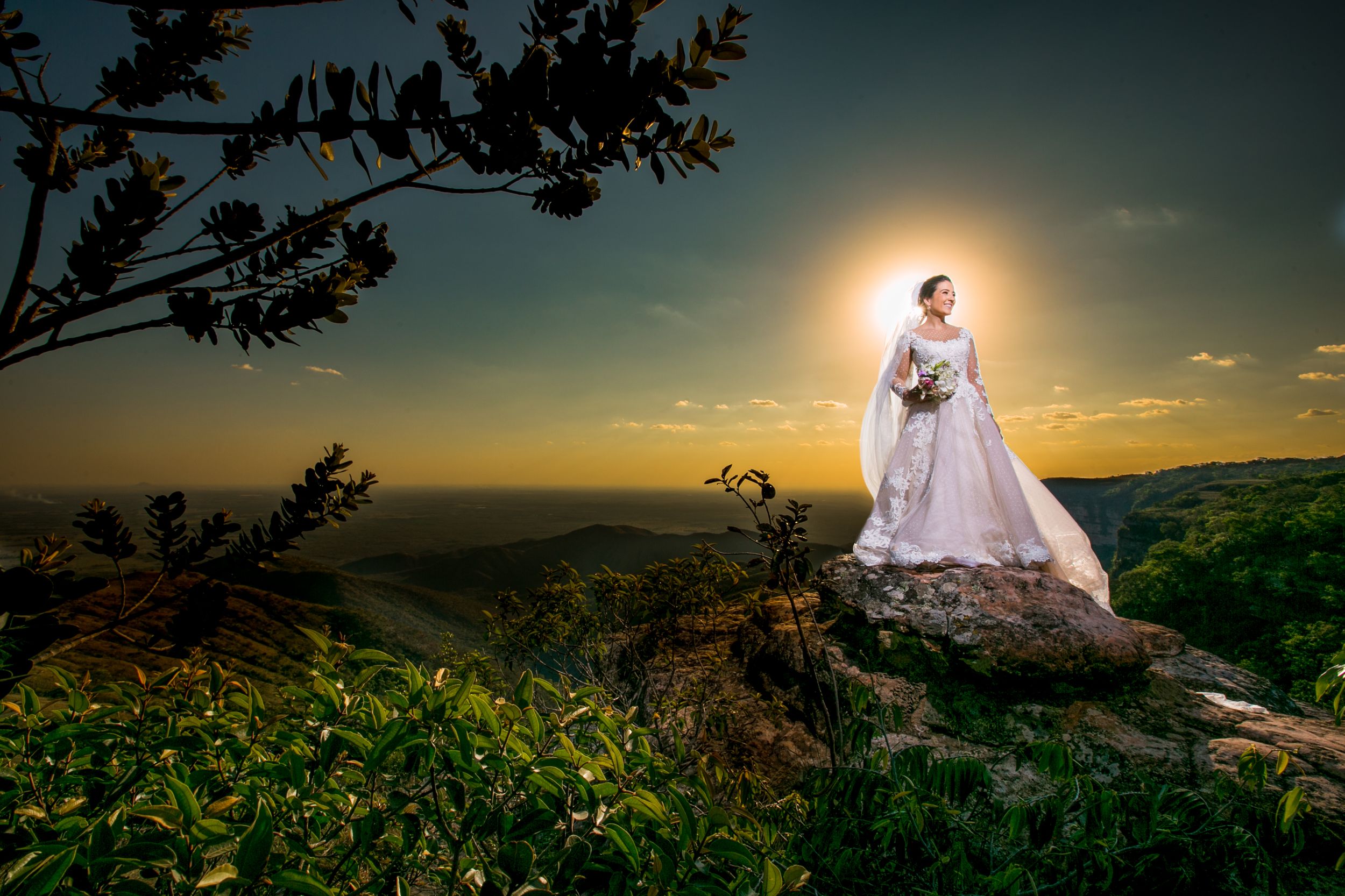 Sunset wedding photography session in a scenic mountain landscape with flowing white dress.
