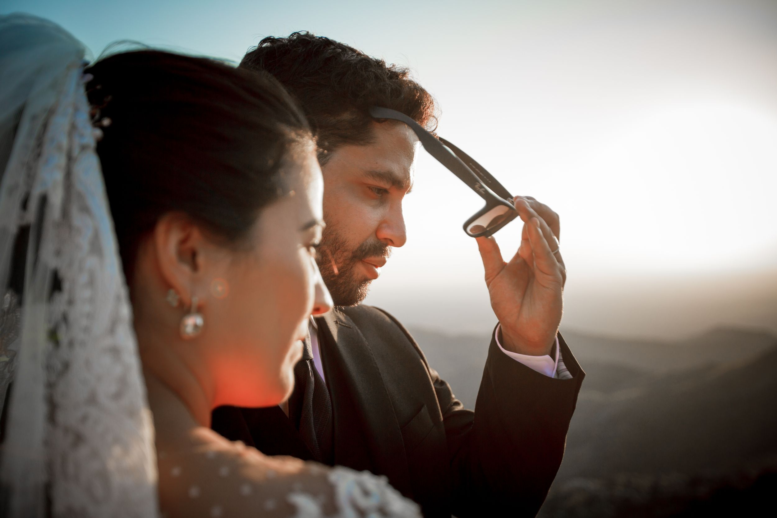 Silhouetted figures against dramatic sky during sunset portrait session.