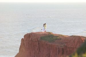 Coastal cliffs and ocean vista create dramatic backdrop for wedding photography.