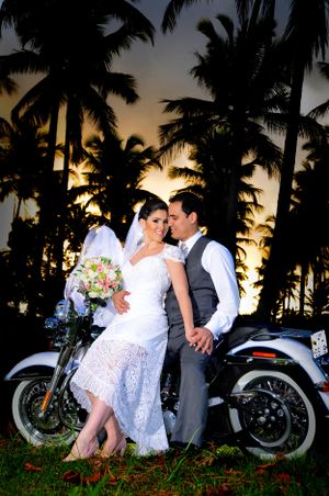 Tropical sunset wedding photos with palm trees and vintage motorcycle silhouettes.