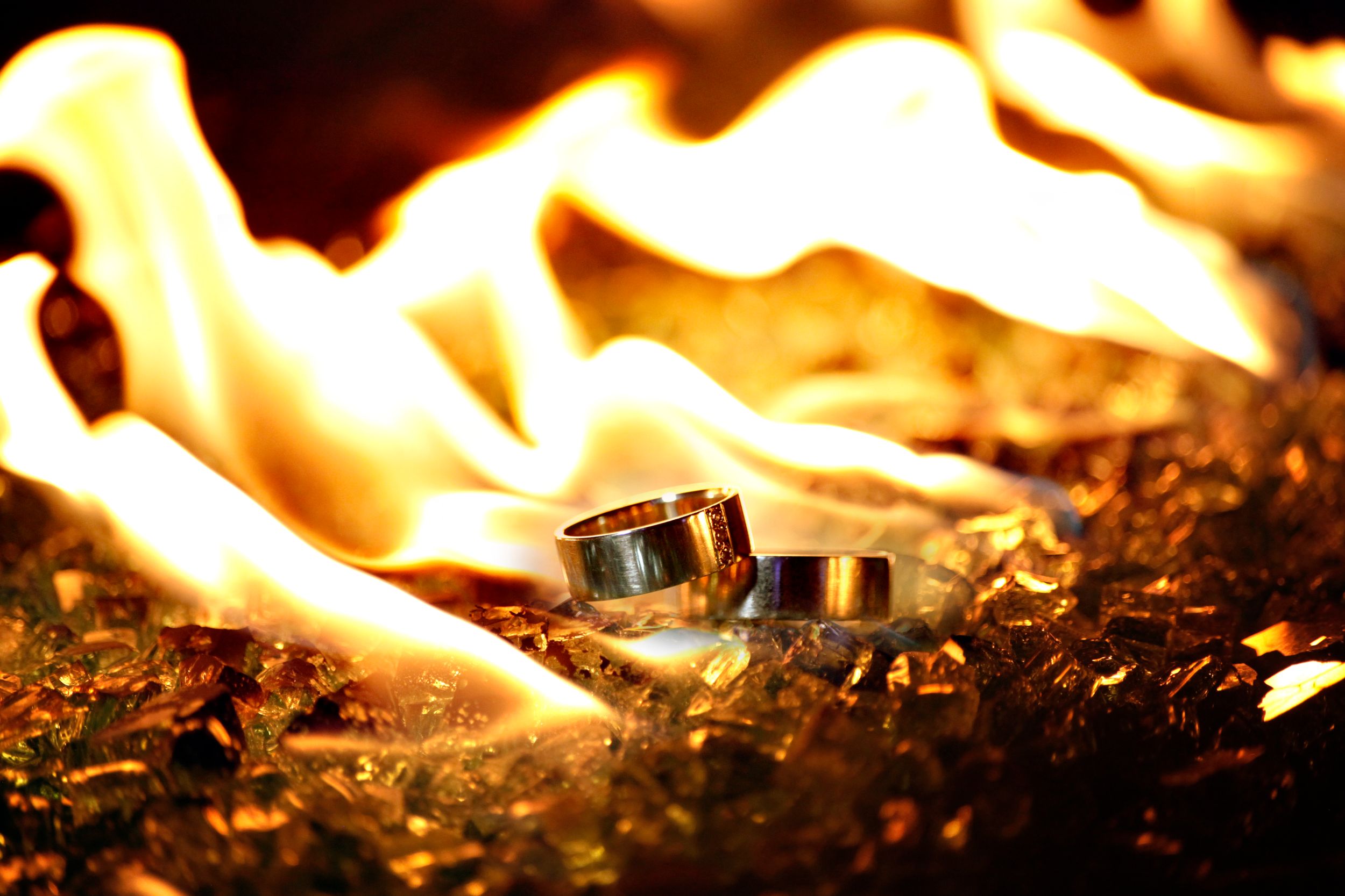 Close-up of wedding rings with dramatic fire and flames in background.