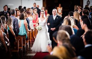Traditional church wedding ceremony with guests seated in wooden pews.