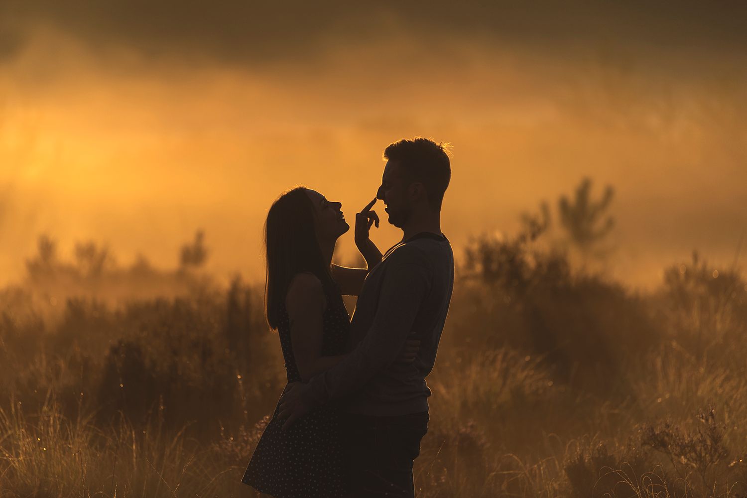 Liefdevol koppel bij een mistige ochtendzon in silhouet