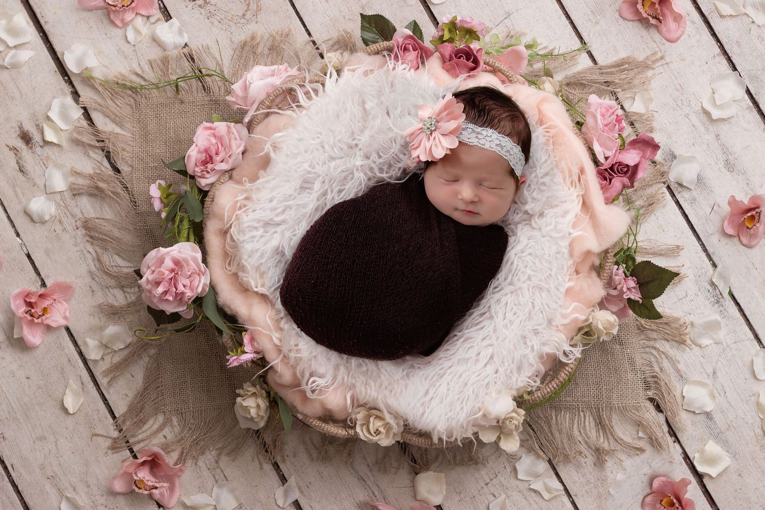 Delicate pink roses and lace create a romantic vintage-style backdrop on white wooden planks.