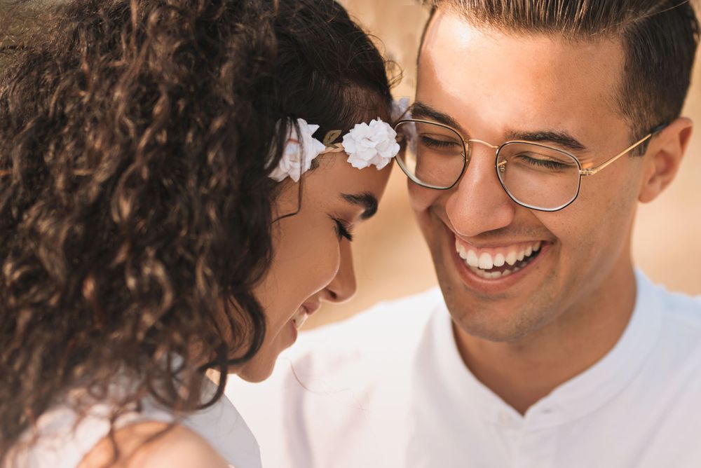 Couple sharing lighthearted moment together during sunset photoshoot.