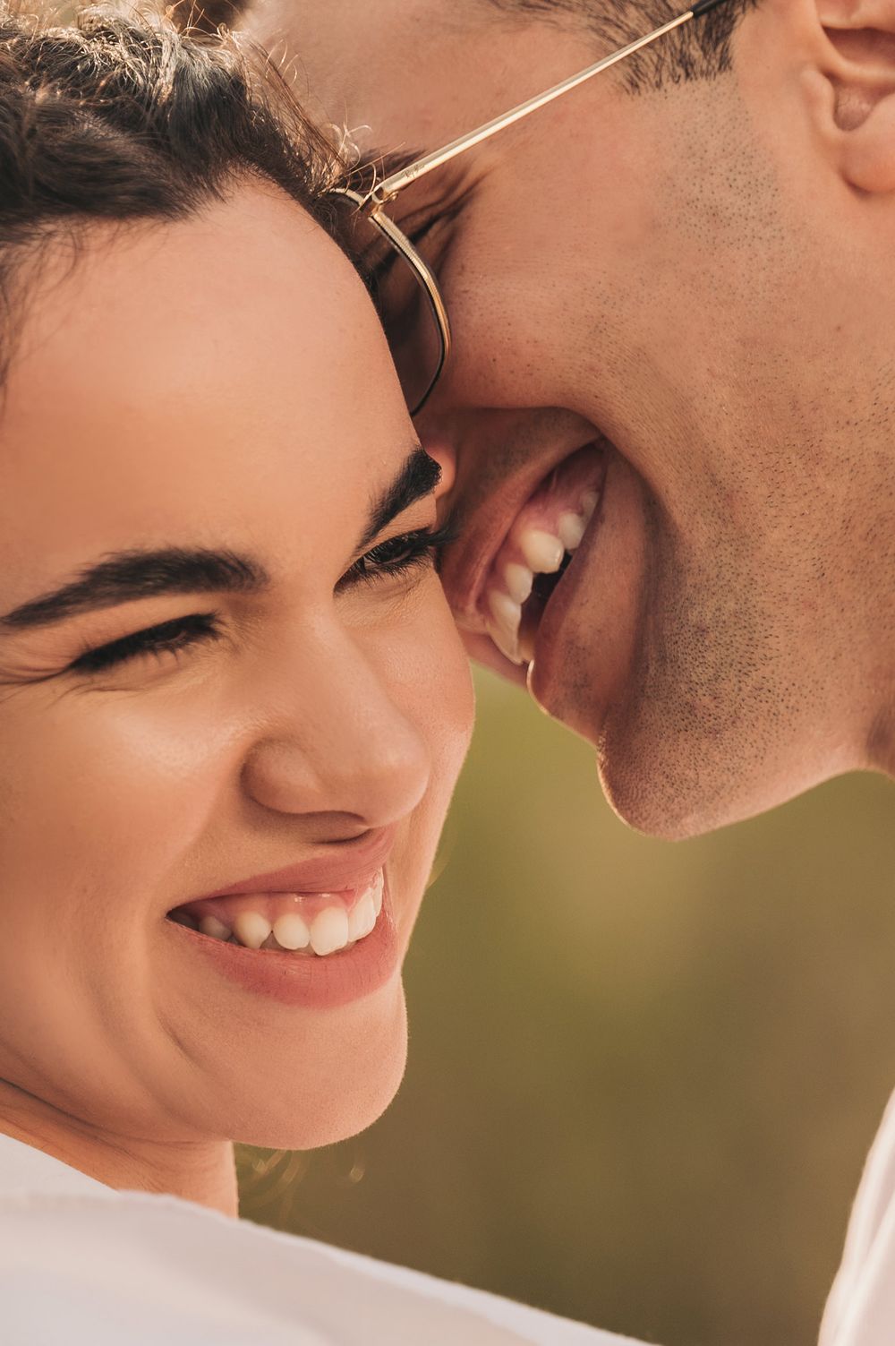 An intimate close-up portrait capturing genuine laughter and joy at sunset.