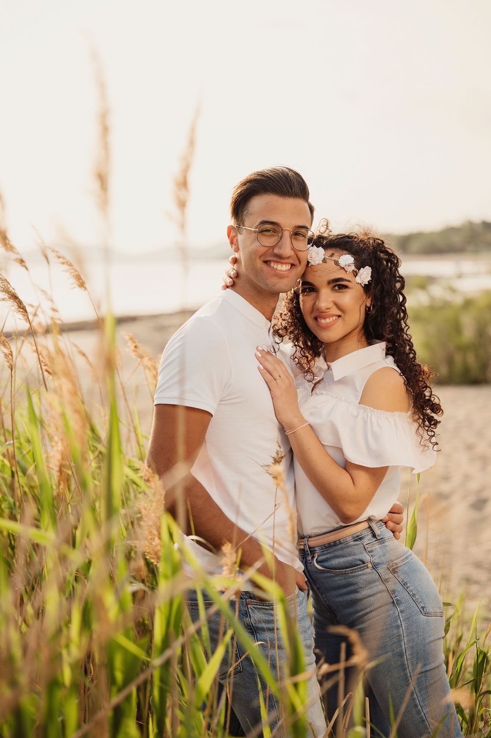 A romantic couple's portrait at the beach with beach grass and soft golden lighting.