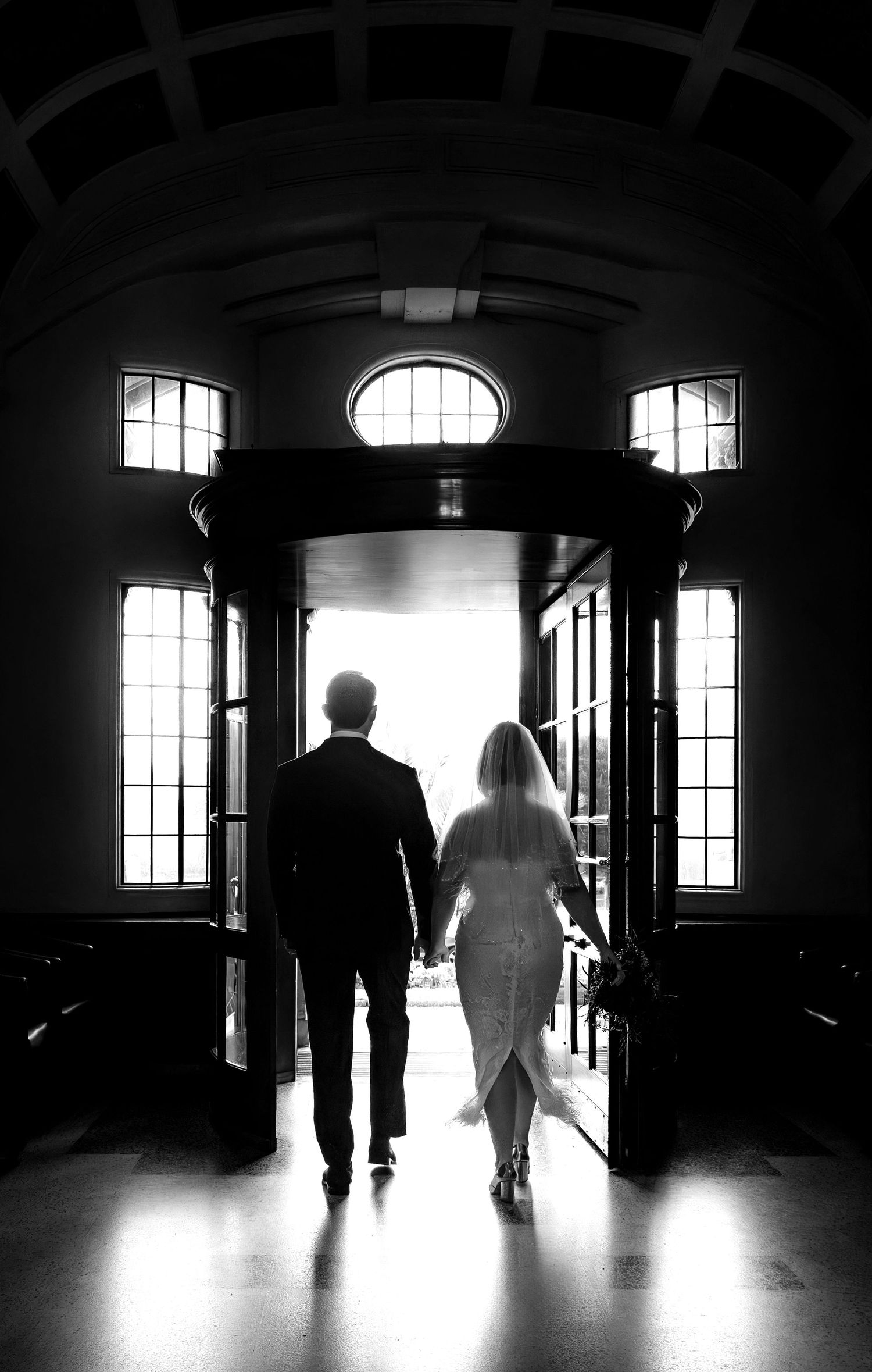 The bride and groom walk out of the Bournemouth registry wedding office. Black and white photograph.
