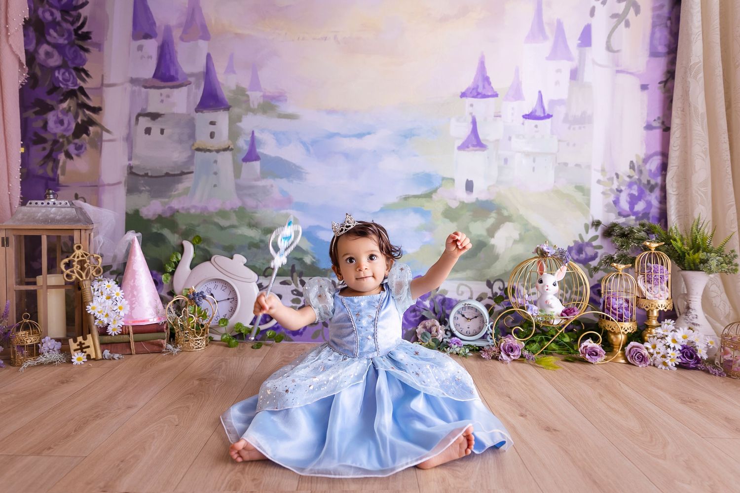 bebe vestida de Princesa se retrata para sus imagenes de 1 ano tiene una varita magica en su mano y un traje azul estilo cinderella