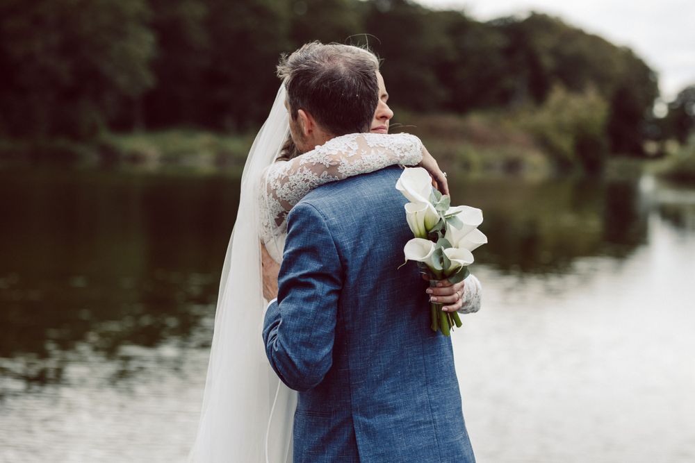Intimate wedding couple moment captured by lakeside.