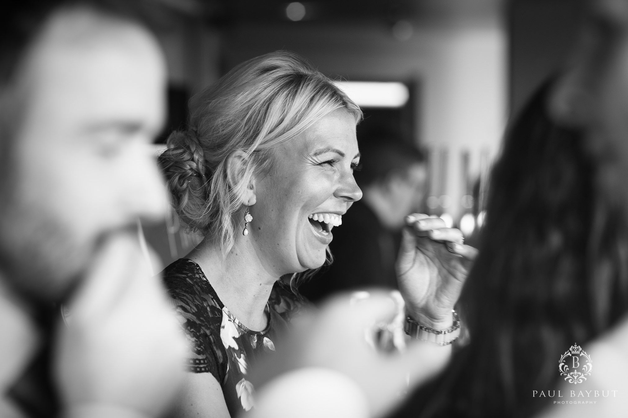 Black and white candid photo showing joyful laughter at a celebration.